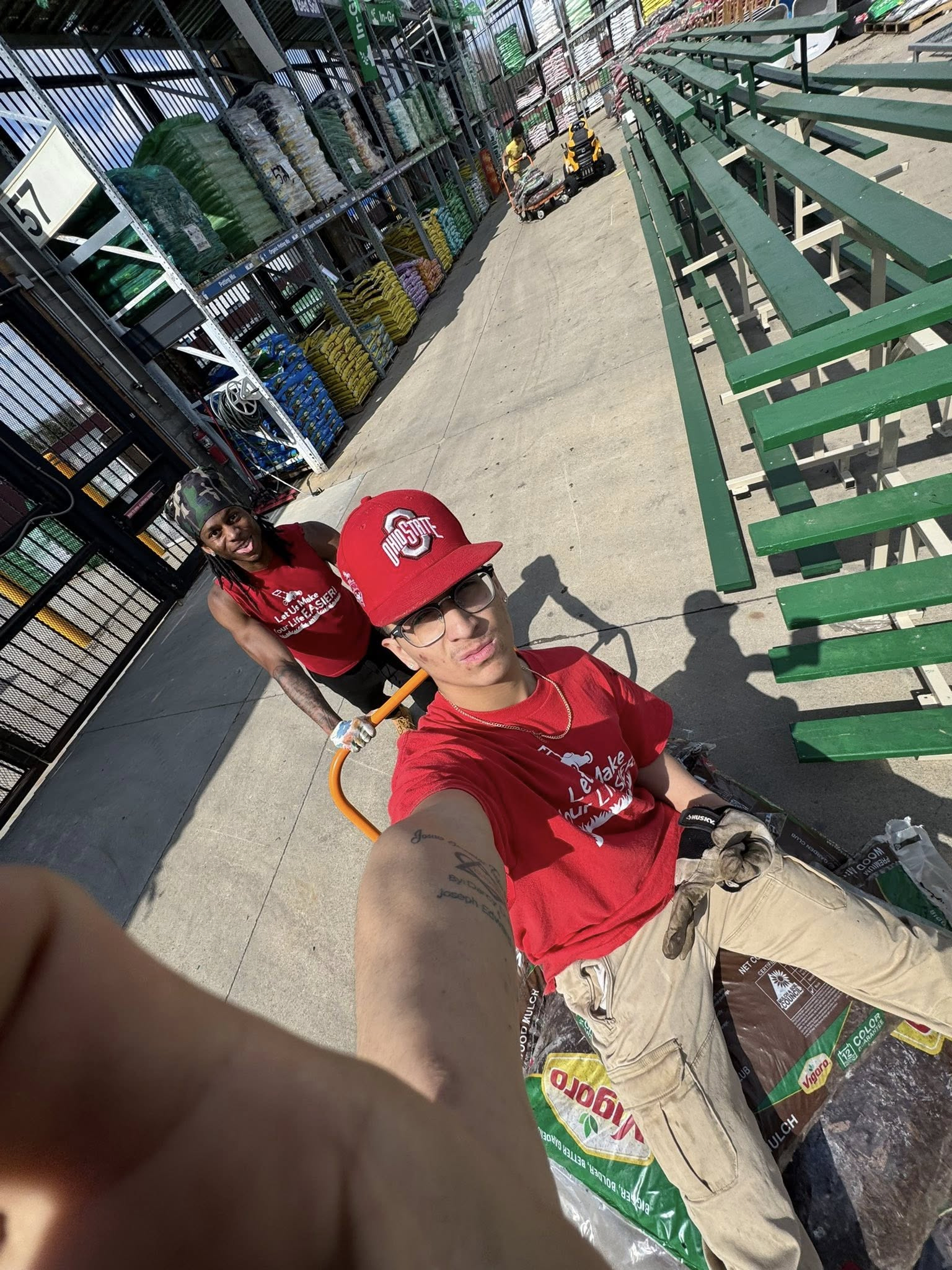 Eddie Fiocca grabbing mulching supplies and taking a selfie with his phone from the store cart